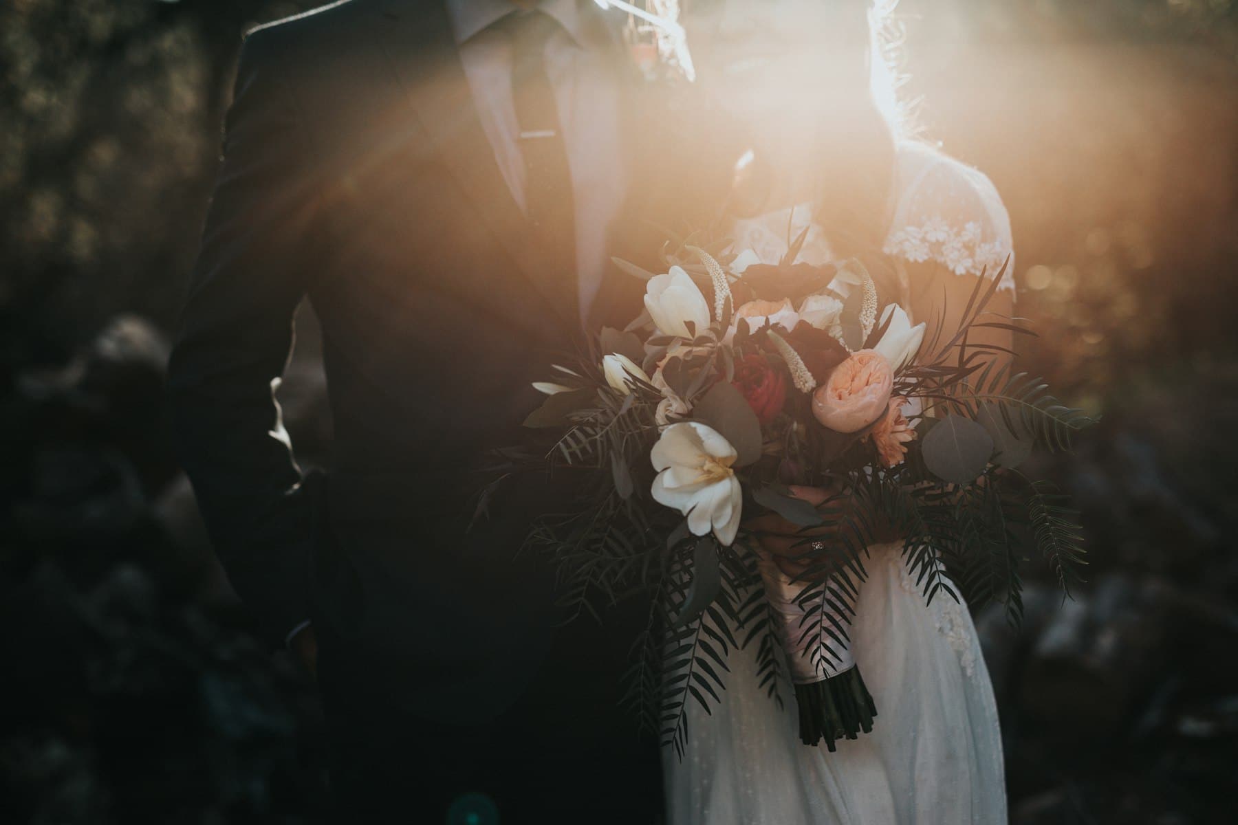 Bride holding a bouquet in warm, low evening light