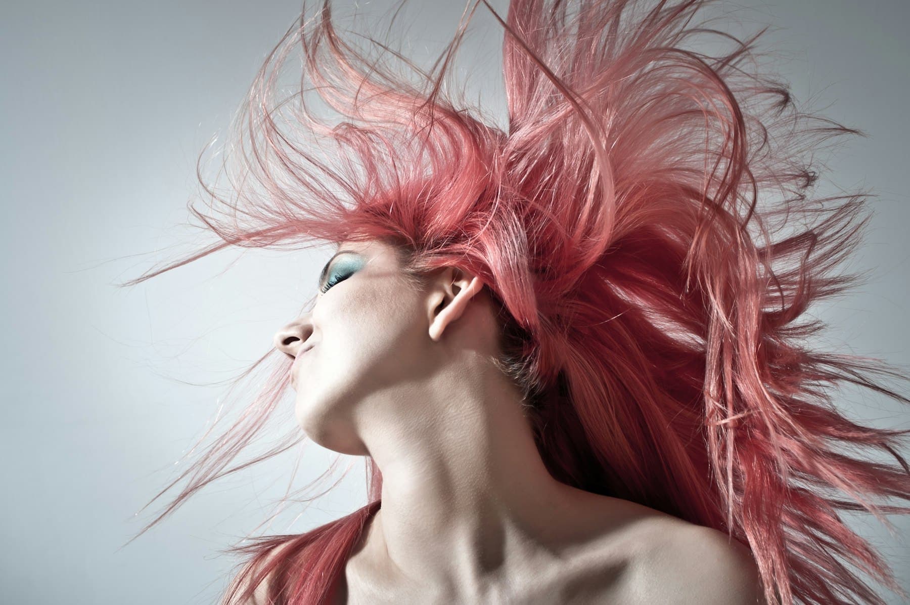 Woman with vivid pink hair tossed in motion