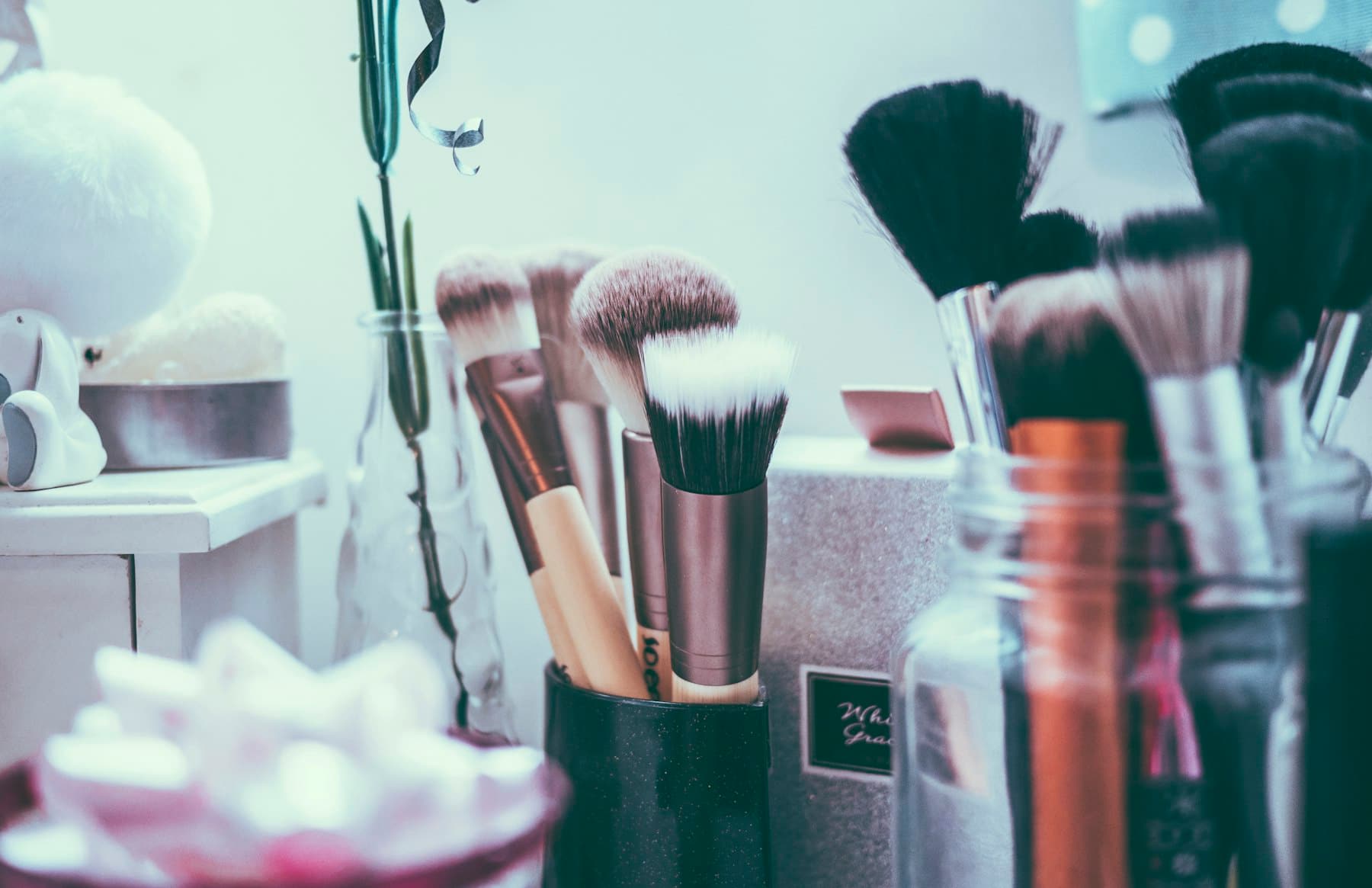 Makeup brushes in holders at a bright makeup station