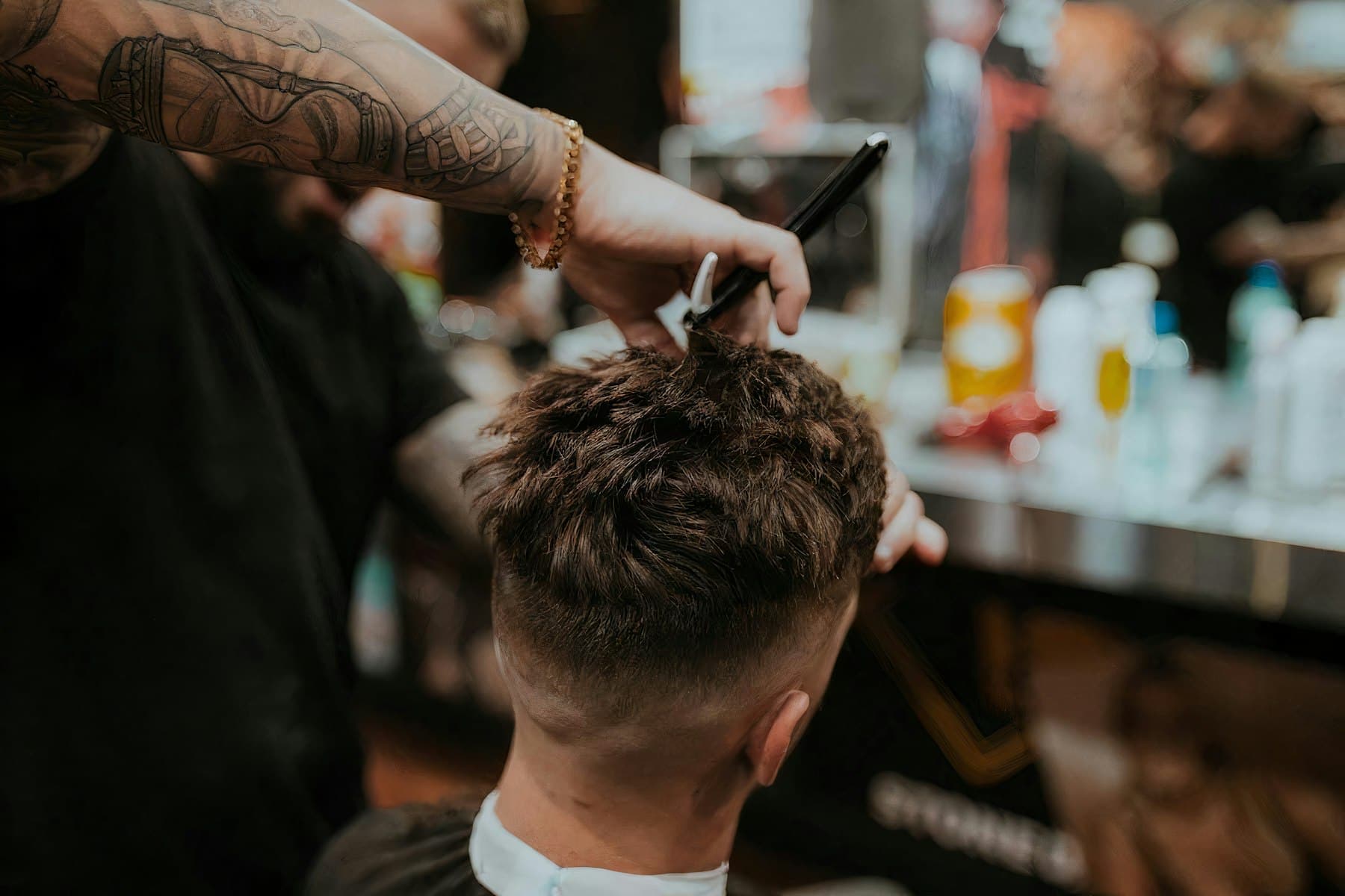 Barber cutting a man's textured hair with scissors