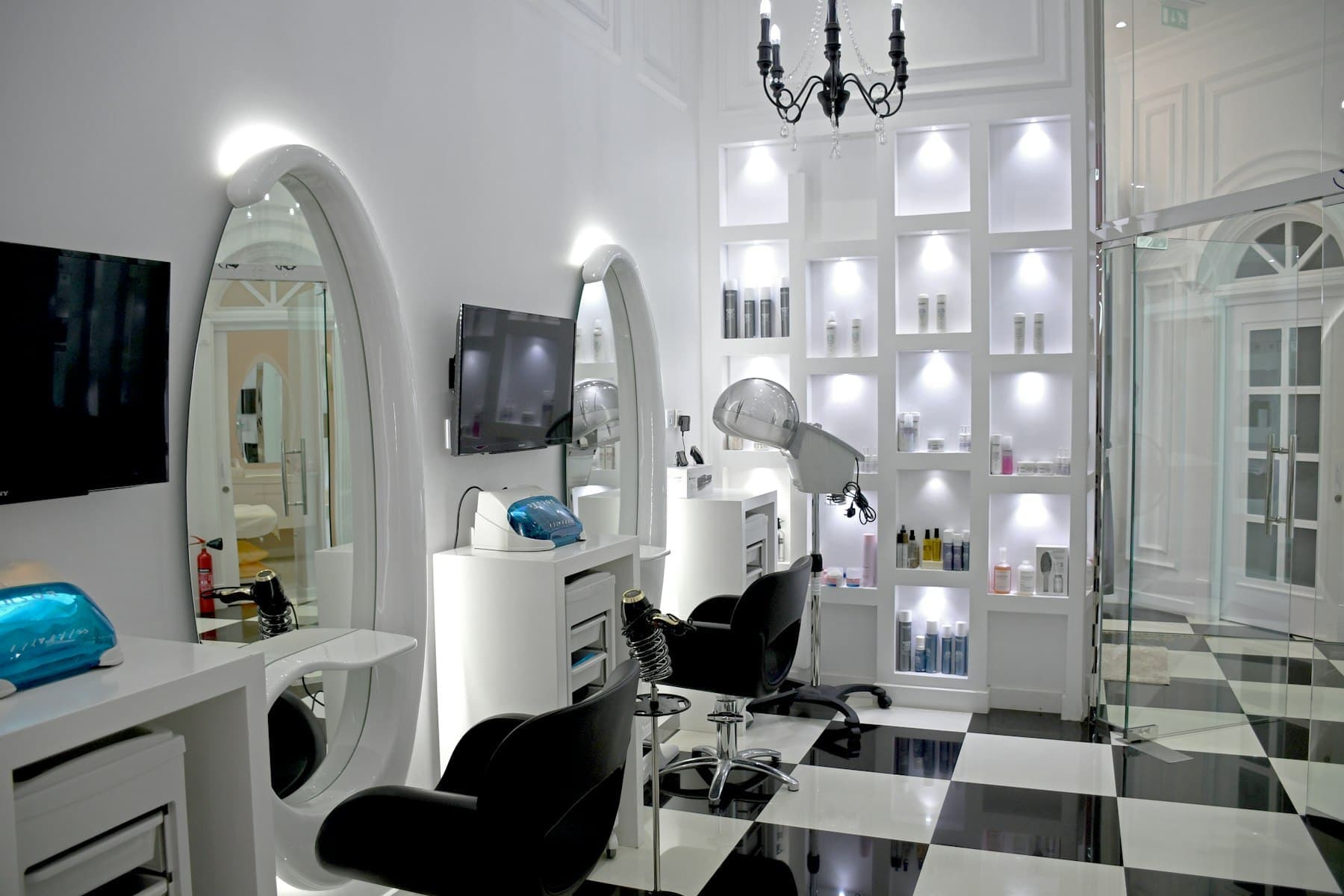 White salon interior with arched mirror and chequered floor