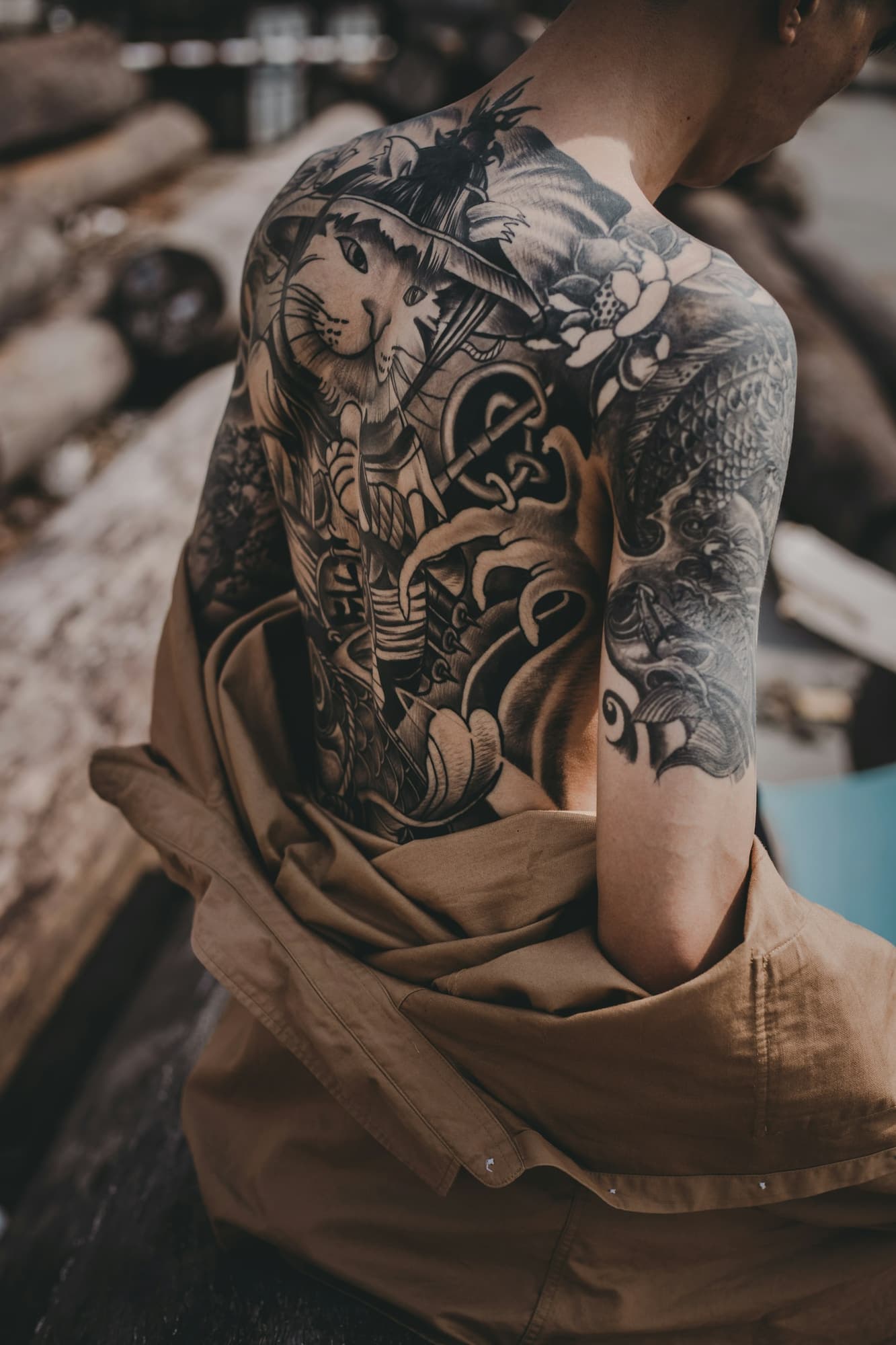 Large black-and-grey tattoo covering a man's back and shoulder